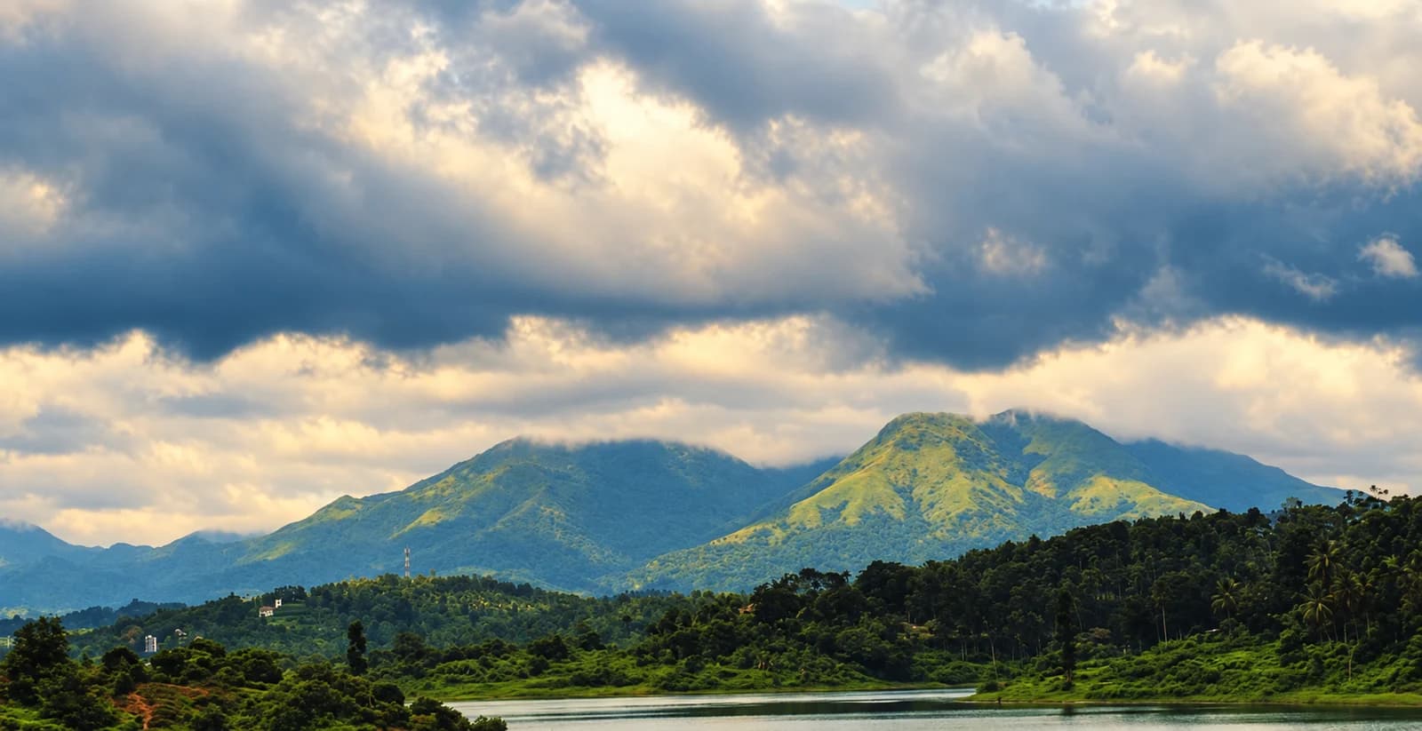 Karapuzha reservoir beneath cloud-covered hills